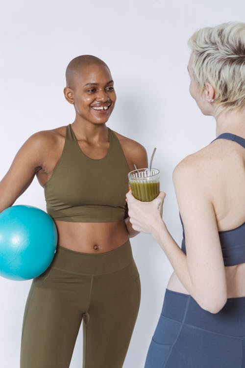 Sportive female athletes talking to each other during training