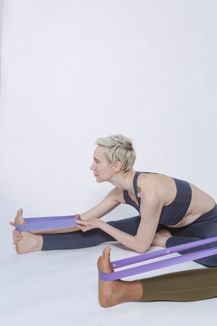 Diverse Sportswomen Exercising With Resistance Bands In Studio