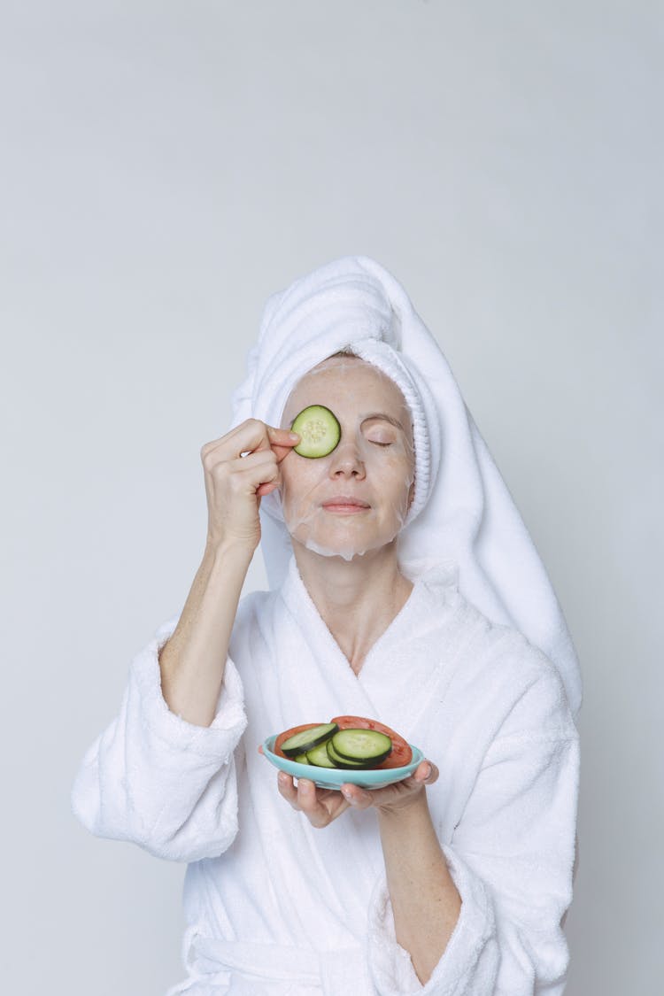 Woman In Sheet Mask Covering Eyes With Cucumber Slices