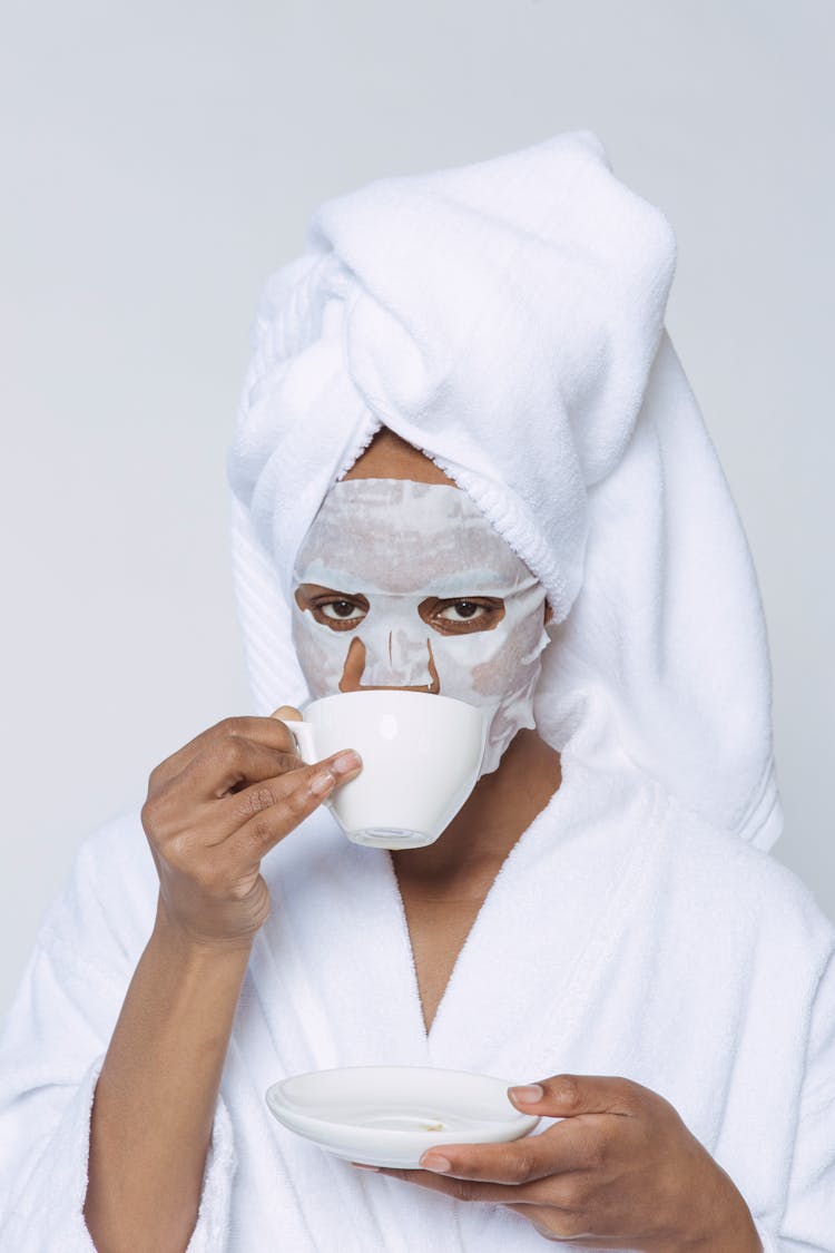 Black Woman In Sheet Mask Drinking Coffee