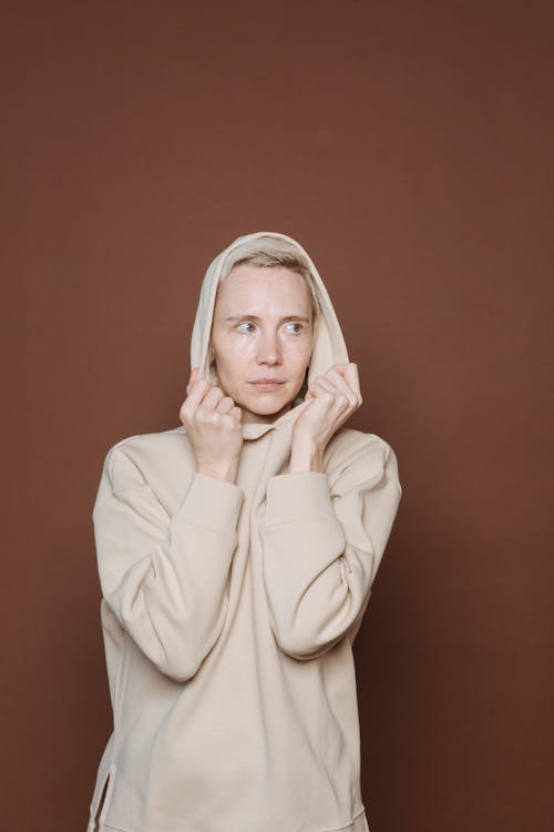 Young woman with hands on hood in studio