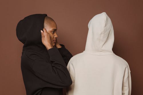 Black woman putting on hood near model