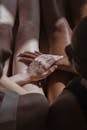 Multiracial women sitting and holding hands together in sunlight