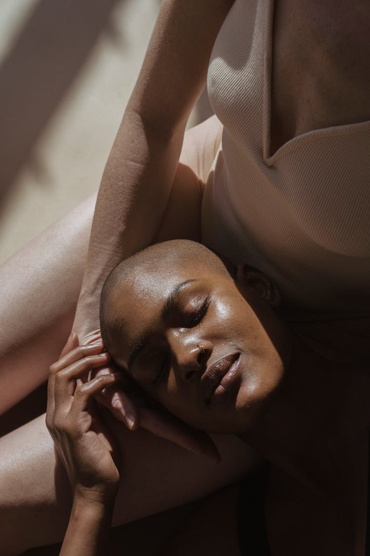 Calm African American Female Lying On Knees Of Woman