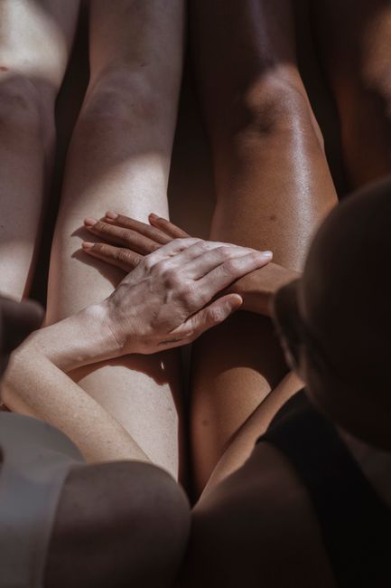 From above of African American woman caressing crop anonymous partner with shades on delicate body skin