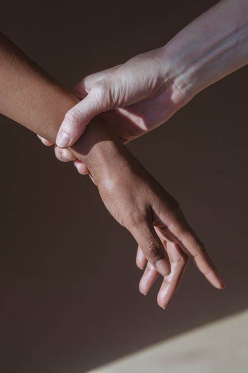 Crop model touching wrist of black woman