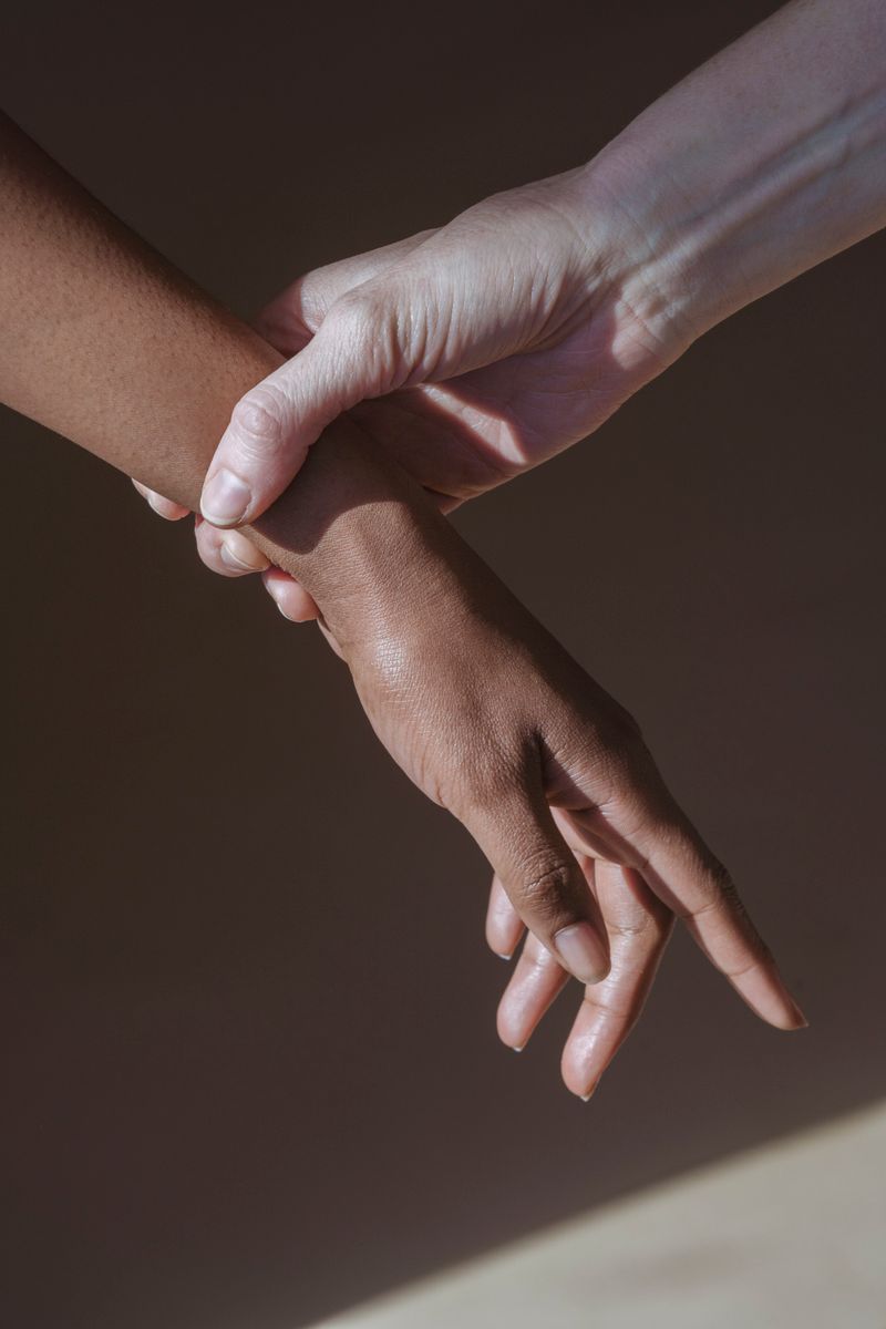 A clinician examines the wrist of a Black woman, the kind of hands-on exam used to check for carpal tunnel syndrome before nerve damage becomes permanent.