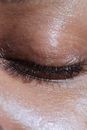 Closeup of crop anonymous ethnic person with long eyelashes and shiny delicate skin in light ray