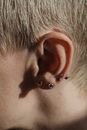 Ear with earring of faceless woman
