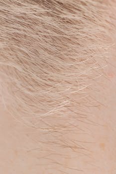 Full frame closeup of skin with short brown and fair hairs on surface