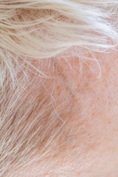 Detailed close-up of white hair and scalp texture, showcasing individual hair strands and skin surface.