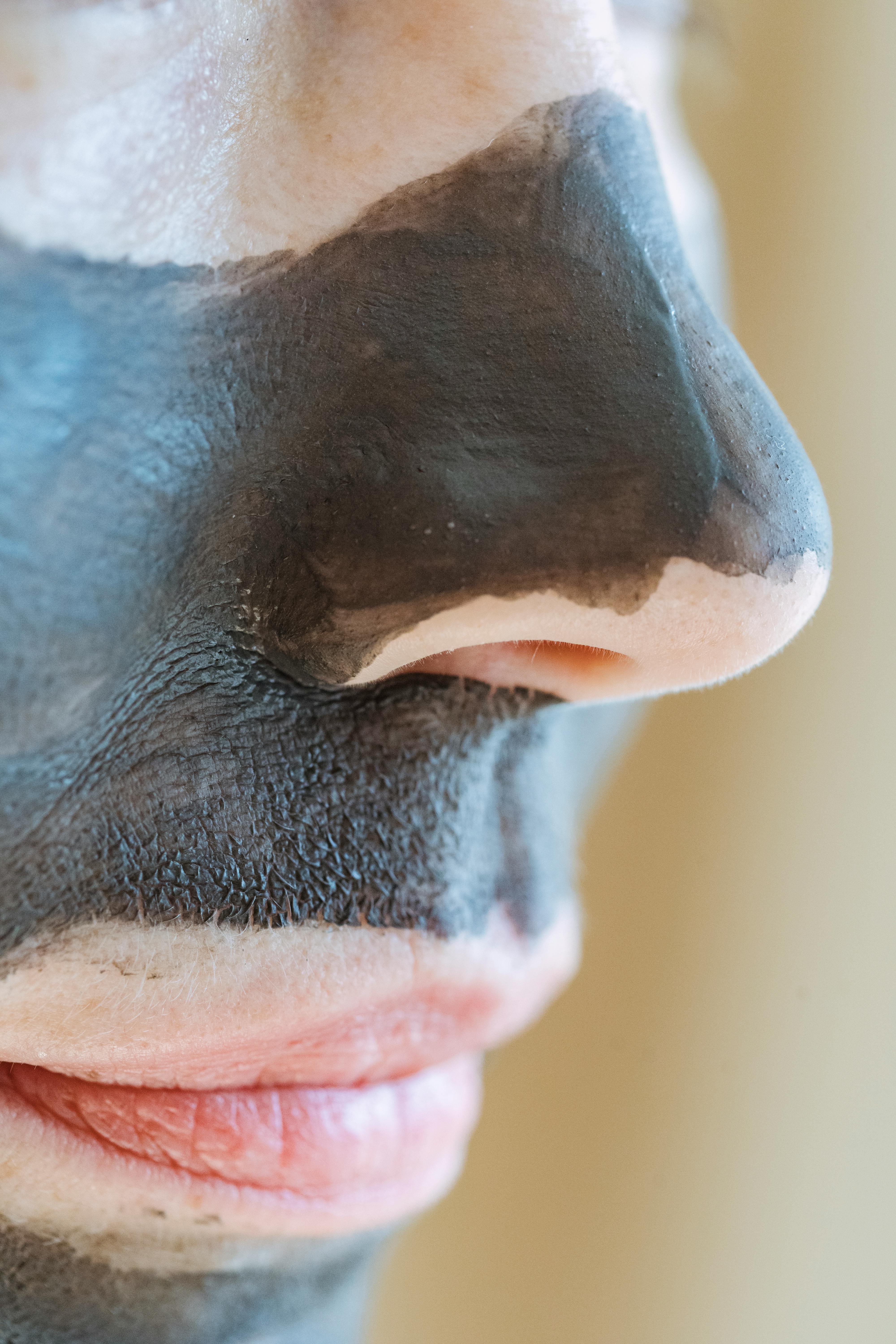 crop woman with clay mask on face