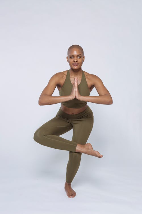 Free Fit black woman in activewear doing Figure Four Stock Photo