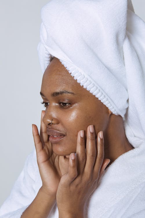 African American woman touching face in bathrobe