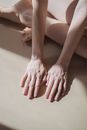 Crop barefoot person touching white floor in sunlight
