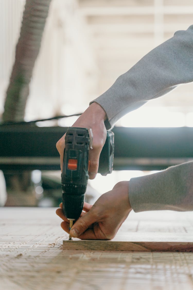 Person Drilling On A Piece Of Wood