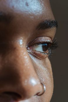 Closeup of crop black lady with shiny face skin and nose piercing looking away