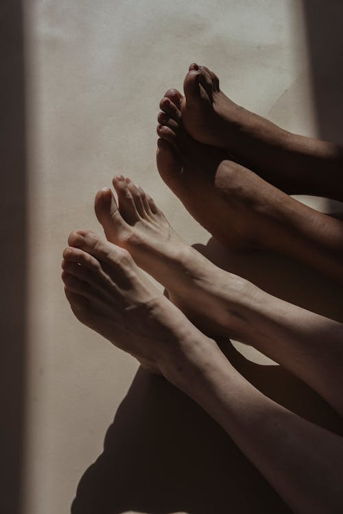 Free Bare feet of crop diverse people on floor Stock Photo