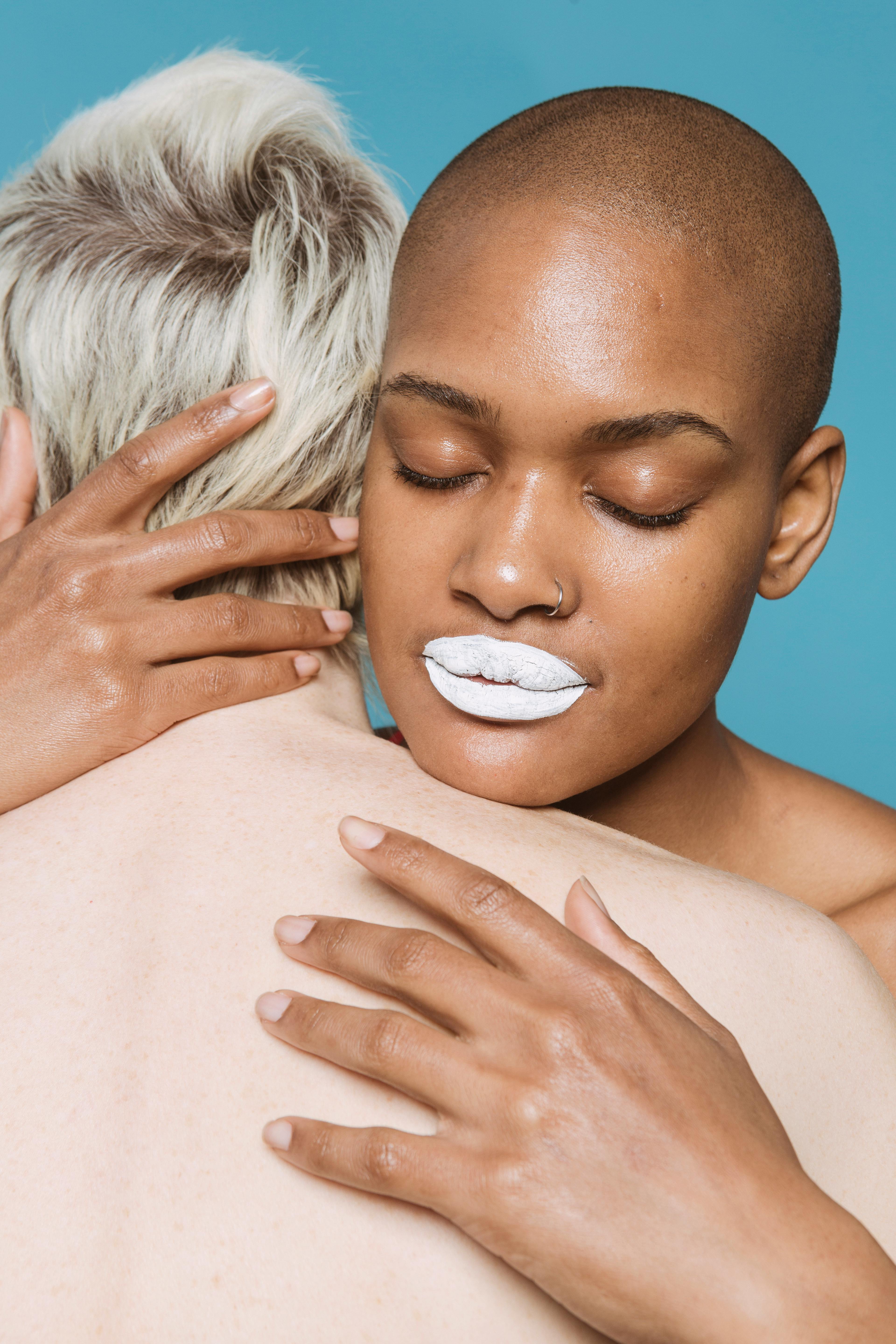 ethnic female with white lipstick hugging partner