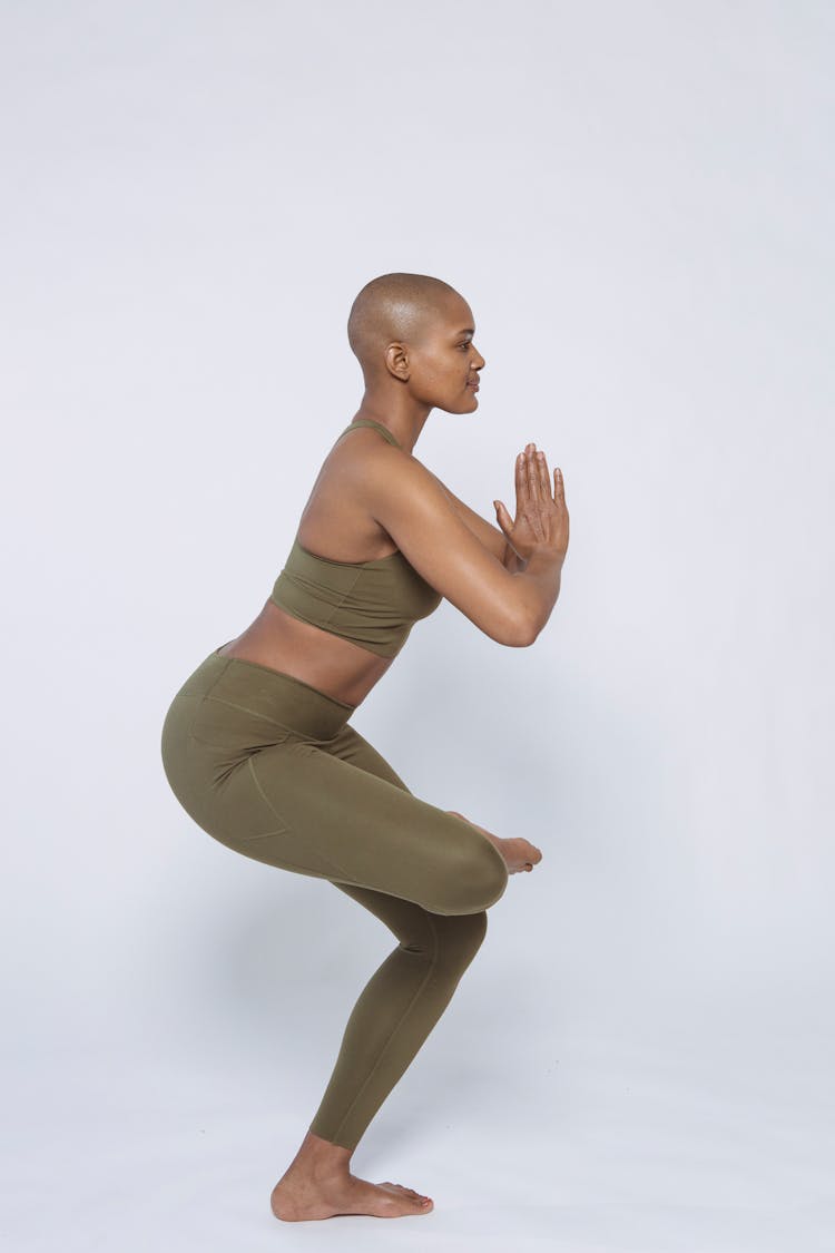 Fit Black Woman Doing Half Lotus Pose In Studio