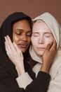 Diverse ladies closing eyes while touching faces of each other