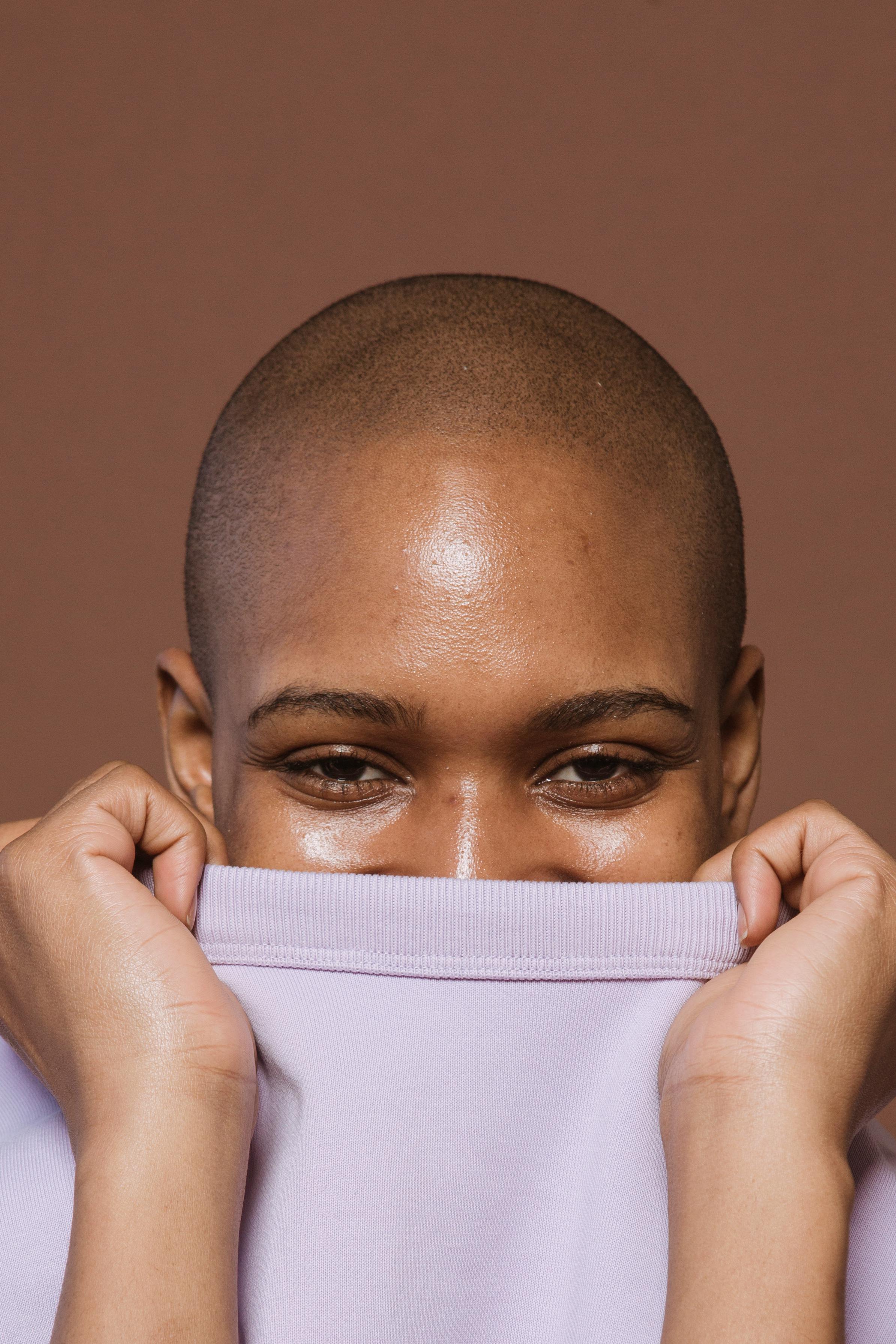 Person styling a bald is beautiful shirt with accessories