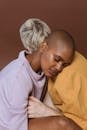 Young African American female model in casual outfit embracing blonde person putting head on shoulder with closed eyes