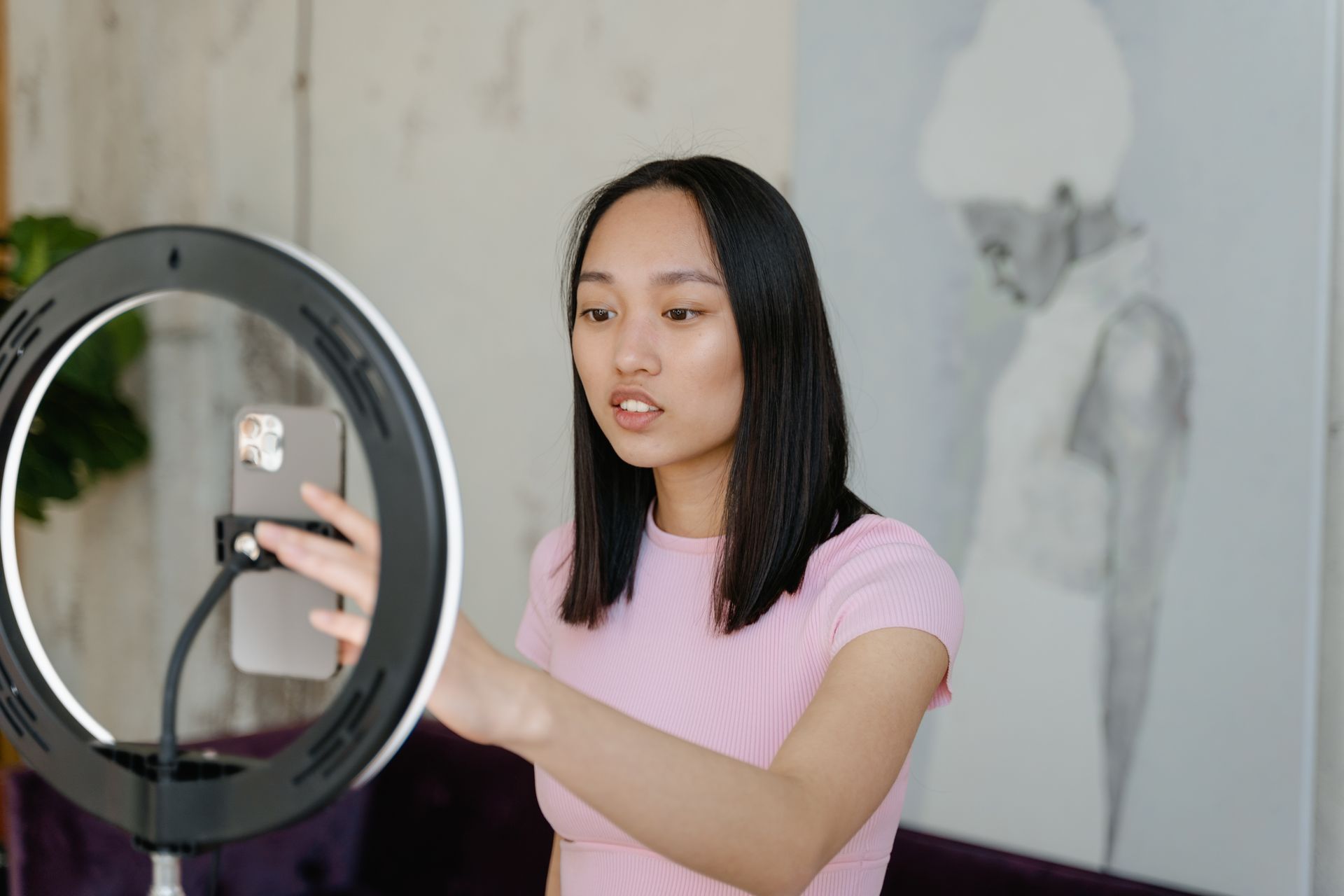 A Woman Using Smartphone and Ring Light