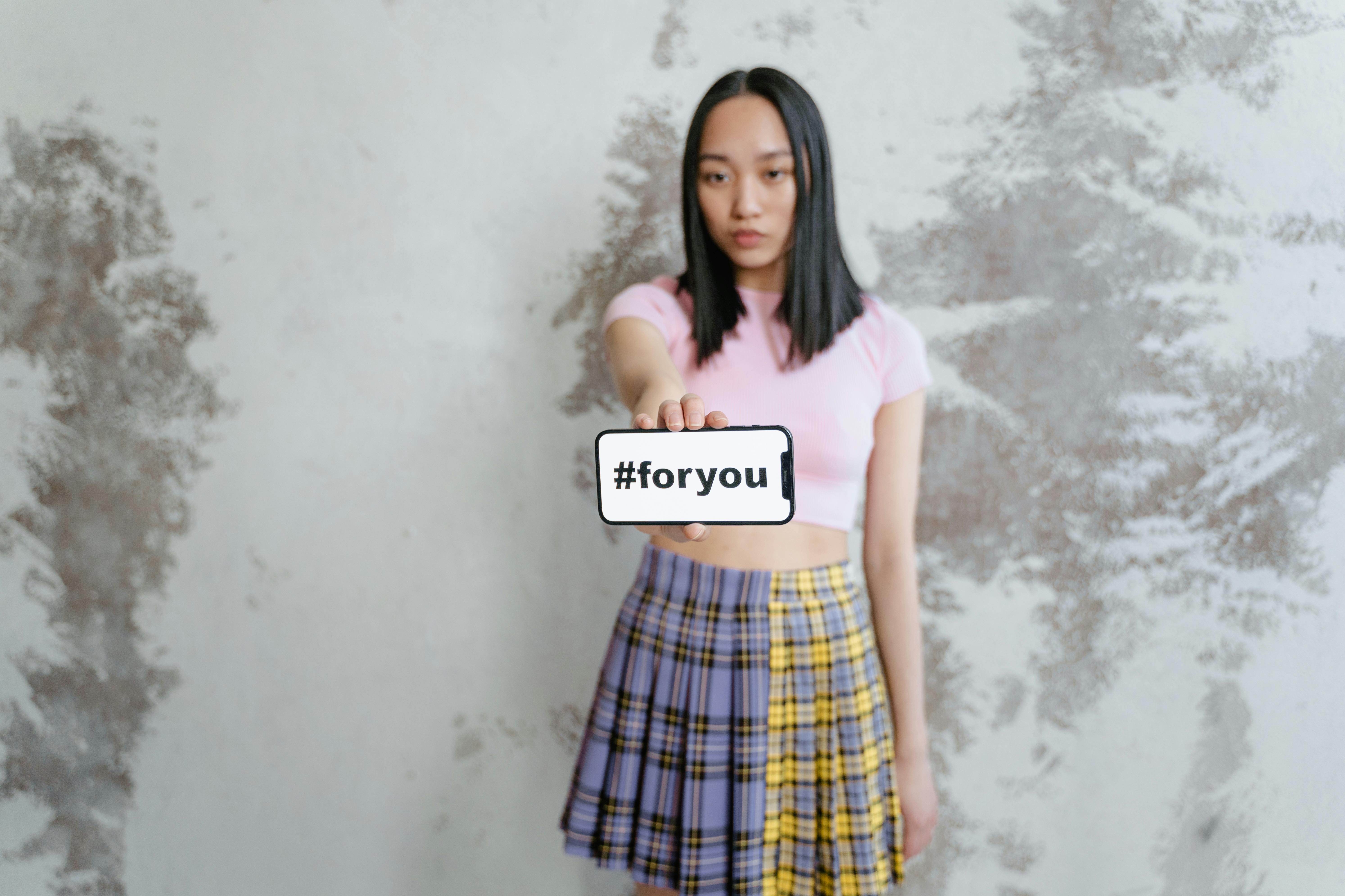 woman in pink shirt and blue red and yellow plaid skirt