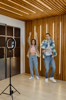 Two stylish young adults dancing in a modern indoor setting, recording content for social media.