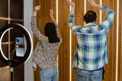 Free Two adults dancing in playful mood at home while recording with a smartphone. Stock Photo
