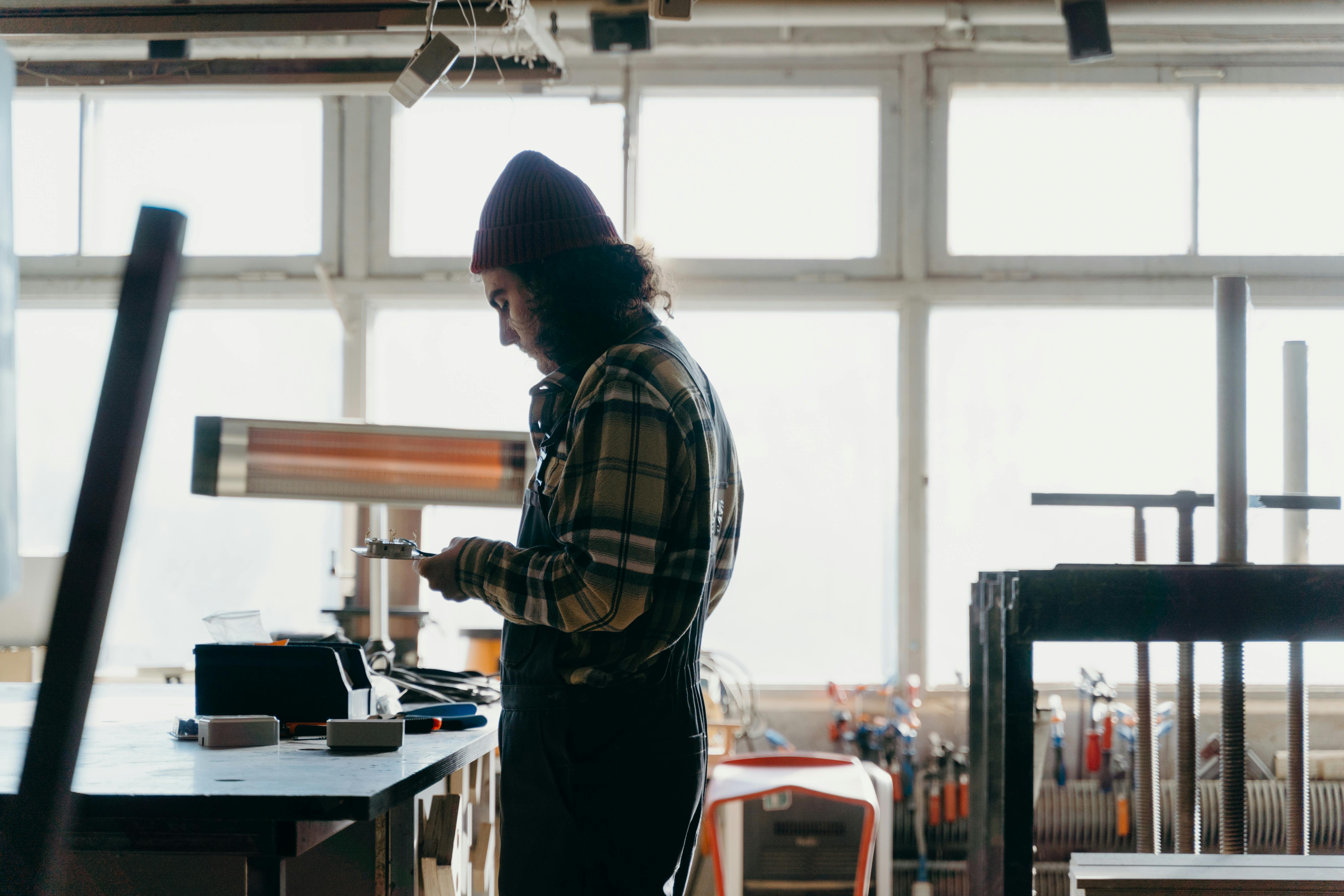 Meseriaș lucrând în atelier cu unelte - exemplu de muncă calificată vs. necalificată