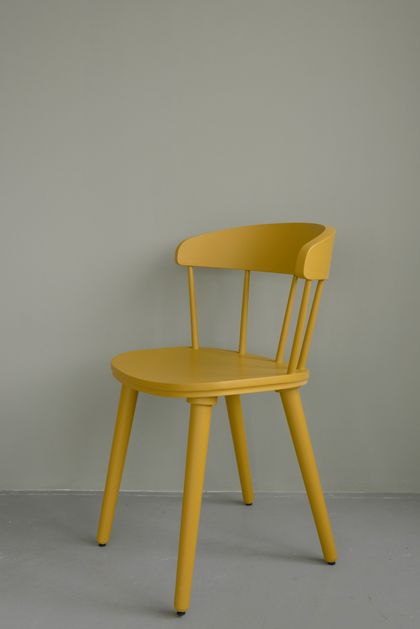Yellow spindle-back wooden chair on a grey studio backdrop — photo by Ksenia Chernaya on Pexels