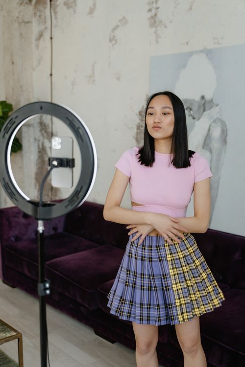 Free A Girl in Pink Shirt is Standing in Front of the Ring Light Stock Photo