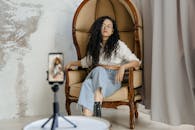 Woman in White Long Sleeve Shirt Sitting on Brown Wooden Chair