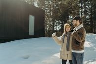 Man in Brown Coat Standing on Snow Covered Ground