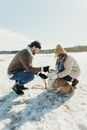 Man in Gray Jacket Sitting on Snow Covered Ground With Dogs