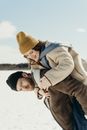 Man in Brown Coat Carrying Girl in White Knit Cap