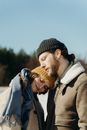 Man in Black Knit Cap Kissing Woman in Gray Coat