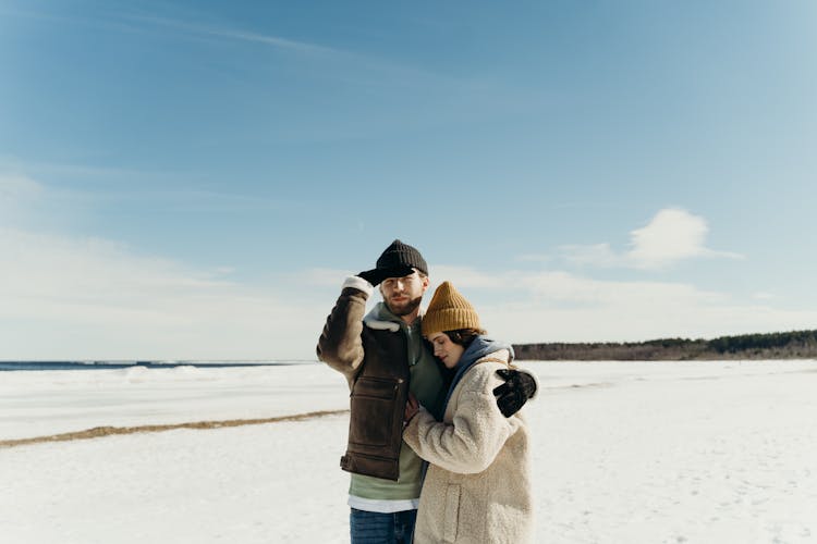 A Couple In Winter Clothing Hugging Each Other