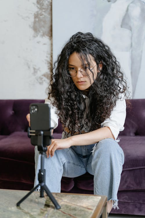 Woman looking at smartphone, touching screen to promote videos on TikTok.