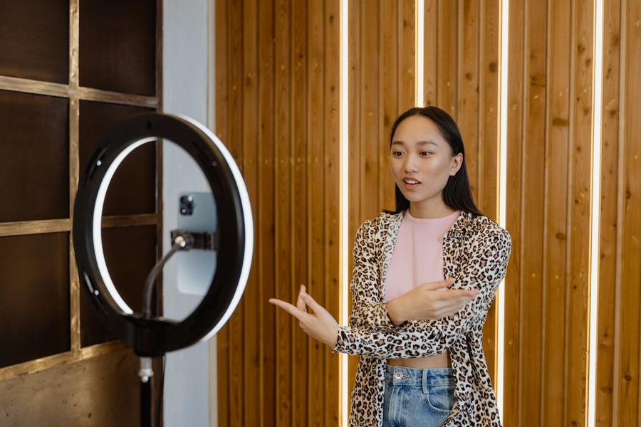 Presenter recording to camera under a soft key light, photo by MART PRODUCTION on Pexels