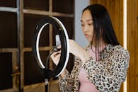 Woman in Brown and White Leopard Print Top Using Smartphone