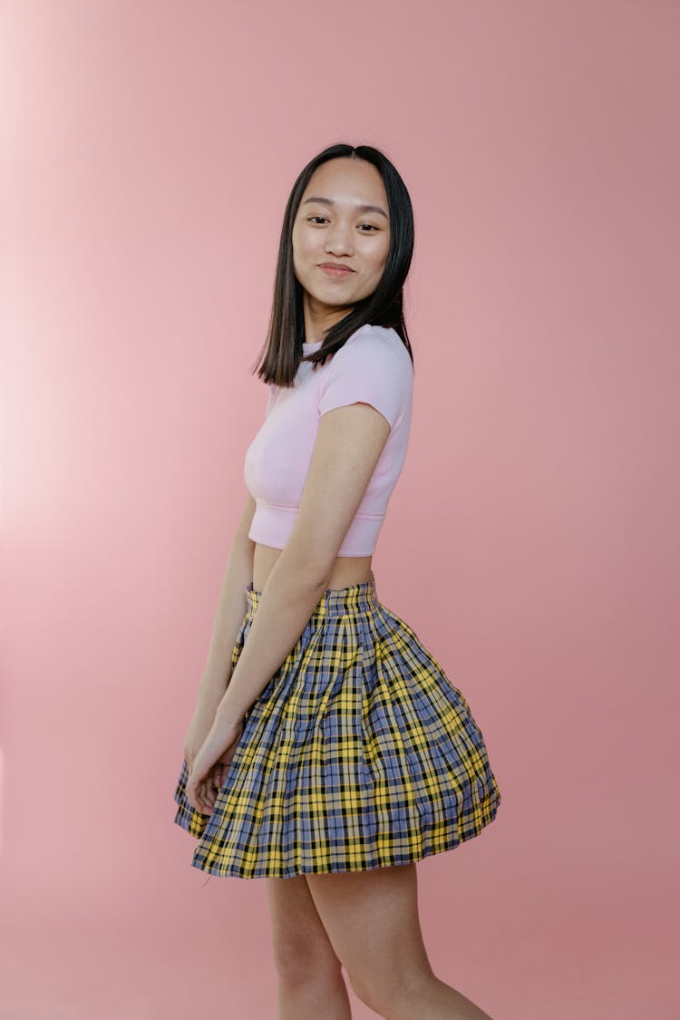 A Woman In Pink Crop Top And Plaid Skirt