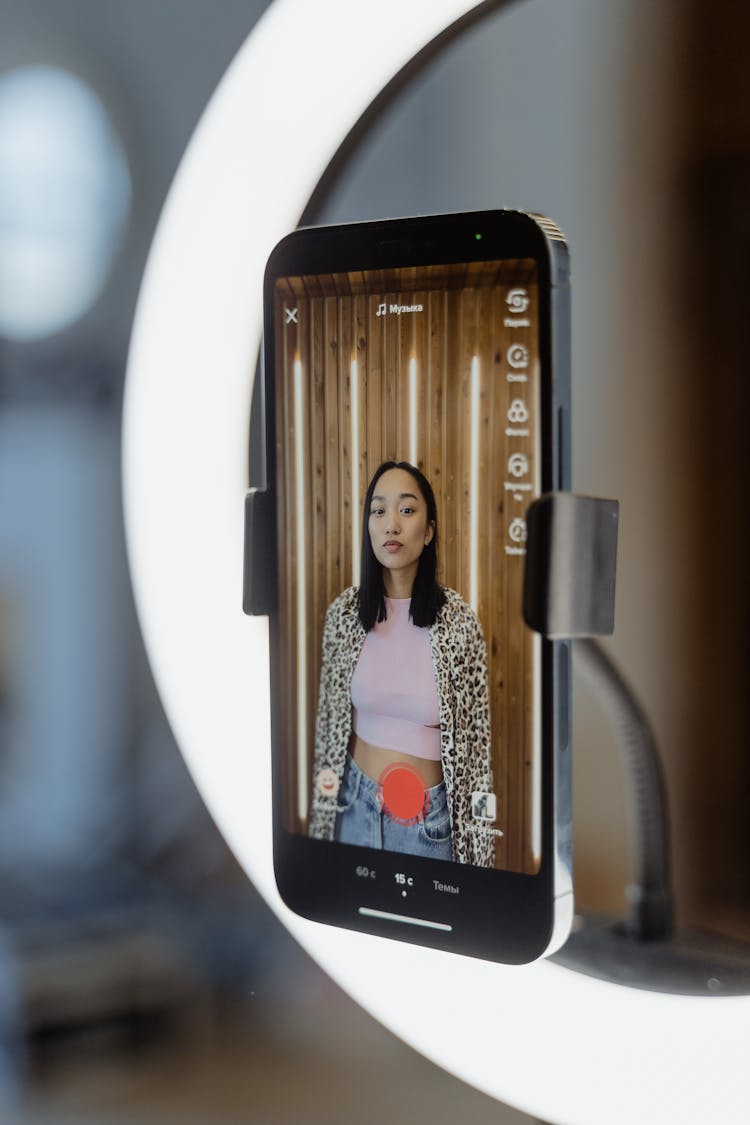 Smartphone Screen Displaying A Woman In Pink Top And Printed Long Sleeves