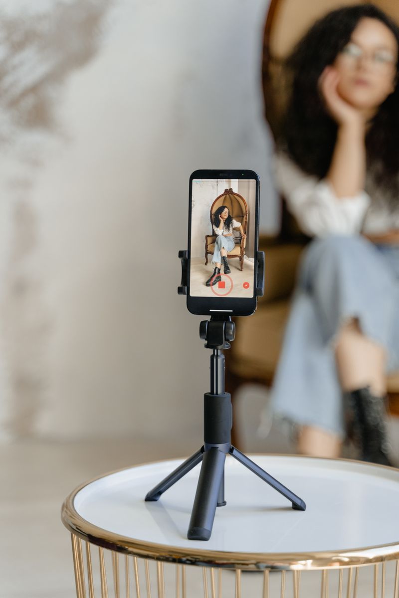 Creadora grabando un video vertical junto a una ventana