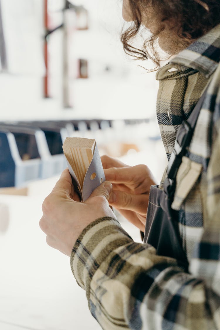 A Person Using A Sandpaper On A Wood