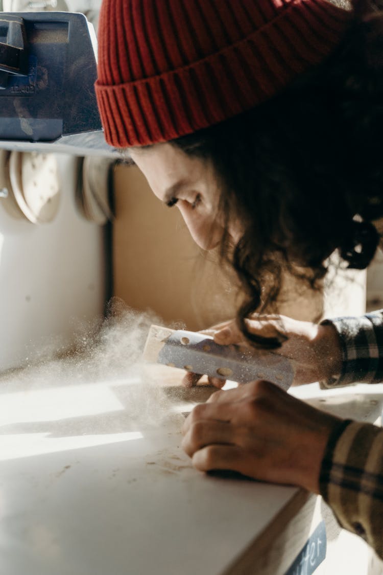 A Carpenter Using A Sandpaper On A Wood