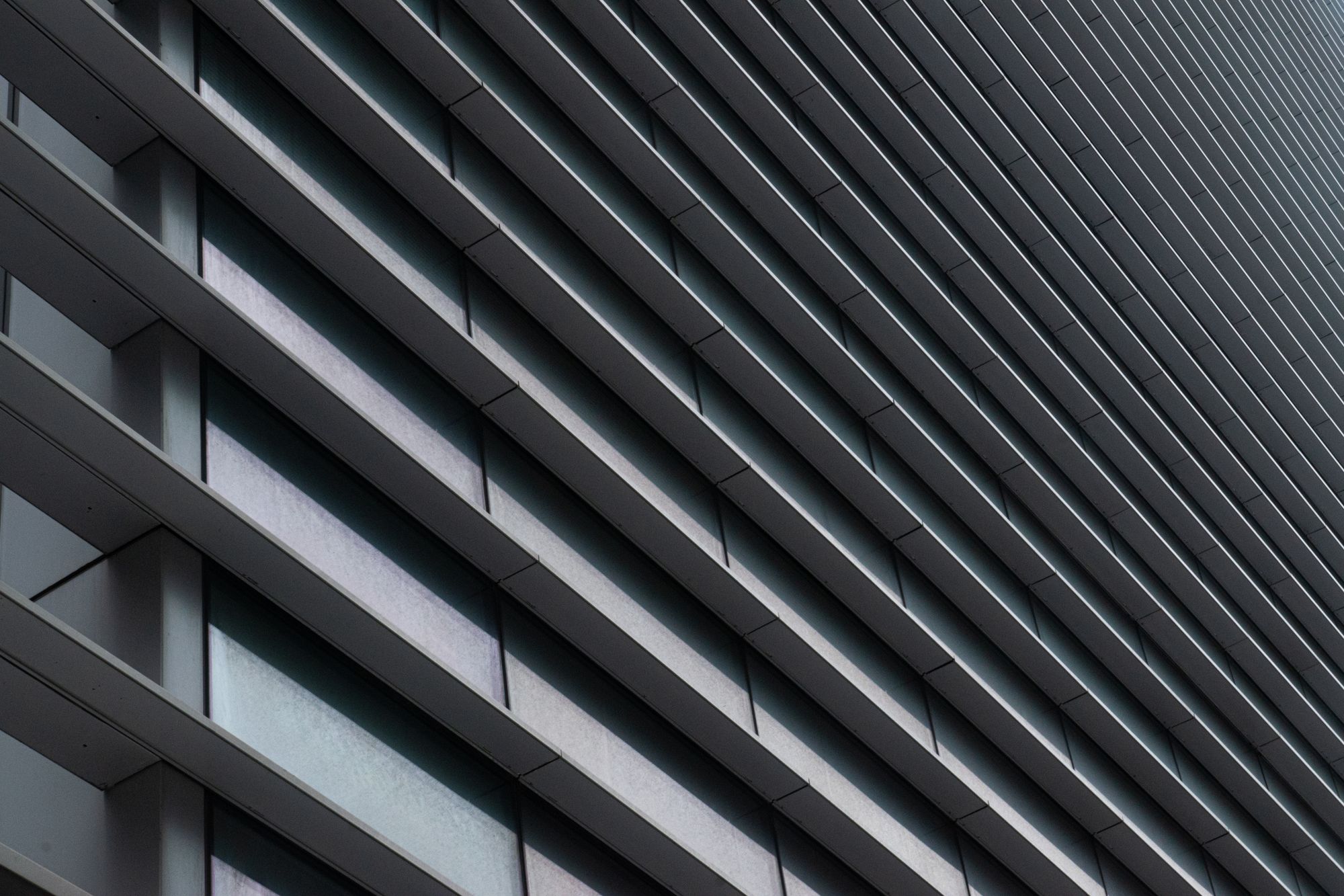Close view of a grey building facade with repeating vertical lines