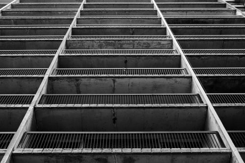 Free Dramatic low-angle shot of a concrete building facade in black and white. Stock Photo